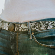 Woman wearing Camo Jelt elastic belt with jeans and a white t-shirt