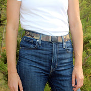 Woman wearing a Jelt True Camo elastic belt with a white t-shirt and jeans