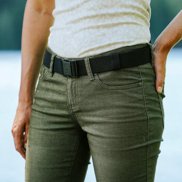 Woman wearing Jelt Venture adjustable belt with green pants and a tank top.