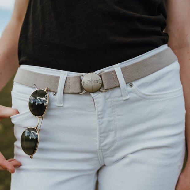 Khaki tan belt featured on a woman wearing white jeans